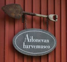 Kuva talon Turvemuseon seinästä, jossa museon kyltti ja vanha lapio